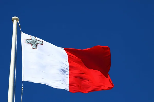 Vlajka Malty proti modré obloze během vítr — Stock fotografie