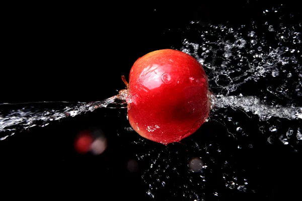 Sladké vody šplouchat a apple na černém pozadí. — Stock fotografie