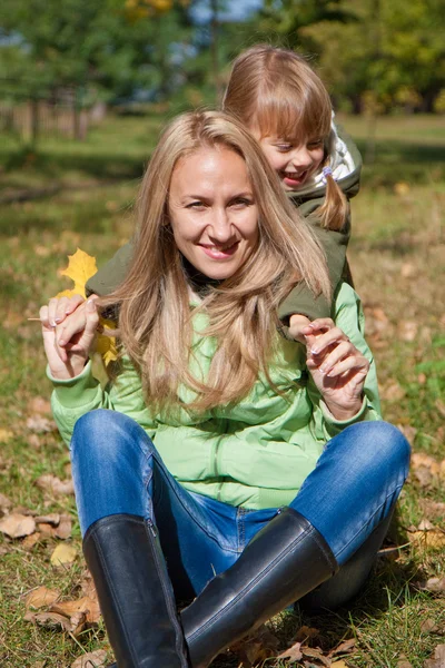 Fiatal anya és a kisgyermek lány az őszi — Stock Fotó