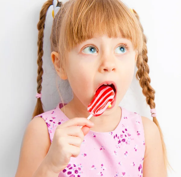 Uma menina olha para cima com doces — Fotografia de Stock