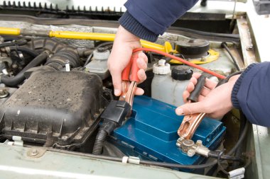 A mechanic using jumper cables clipart