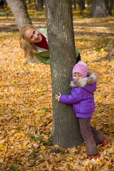Donna fugge con la figlia nel parco autunnale — Foto Stock