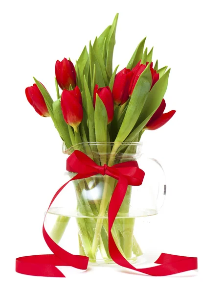 Красные тюльпаны в вазе с красной лентой — стоковое фото