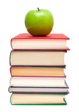 Kitap yığınının üzerinde elma
