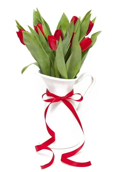 Tulipas vermelhas em um vaso com uma fita vermelha isolada no branco — Fotografia de Stock