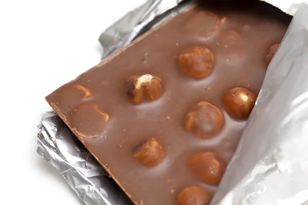 Mléčná čokoláda s lískovými oříšky zabalené izolovaných na bílém — Stock fotografie