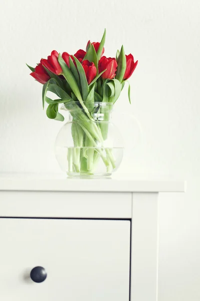 Beautiful red tulips on a white table — Stock Photo, Image
