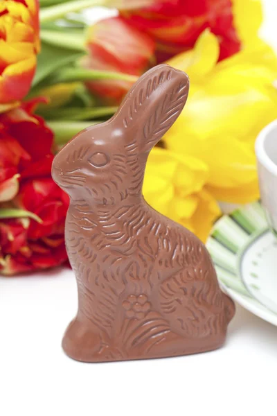 Пасхальный шоколадный кролик, тюльпаны и чай — стоковое фото