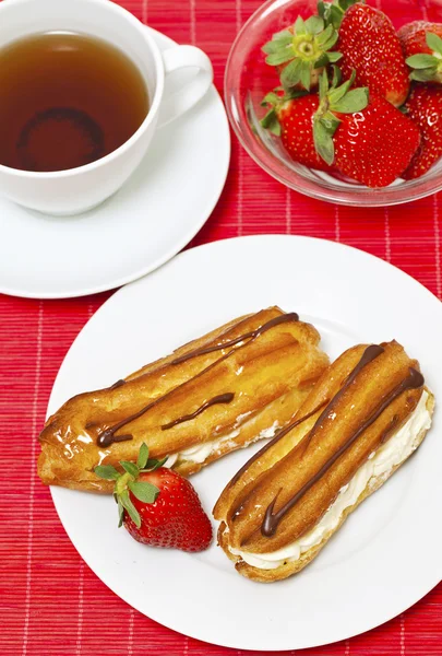 Bouffée de crème fraîche avec crème fouettée et fraise et tasse de te — Photo