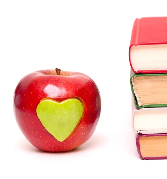 Manzana con corazón verde y pila de libros — Foto de Stock