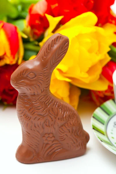 Coniglietto di cioccolato pasquale, tulipani e tè — Foto Stock