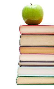 Kitap yığınının üzerinde elma