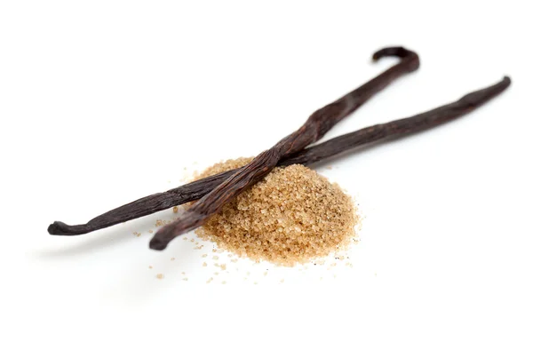 Vanilkové lusky a hnědé vanilkového cukru izolovaných na bílém poz — Stock fotografie