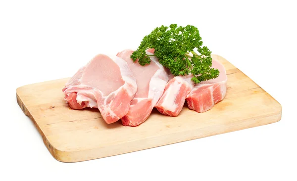 Trozos de carne y manojo de perejil en la tabla de cortar aislado en —  Fotos de Stock