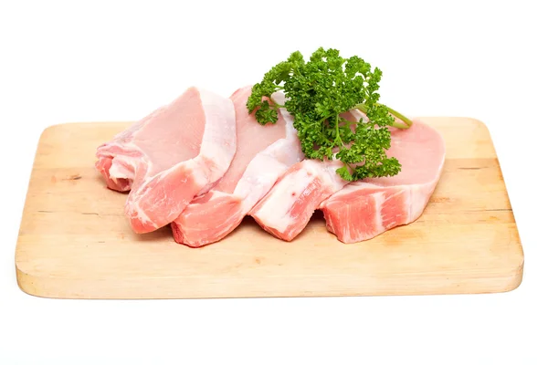 Kawałki mięsa i pęczek pietruszki na deska do krojenia na tle — Zdjęcie stockowe