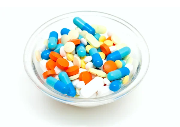 Pílulas diferentes em uma tigela de vidro — Fotografia de Stock