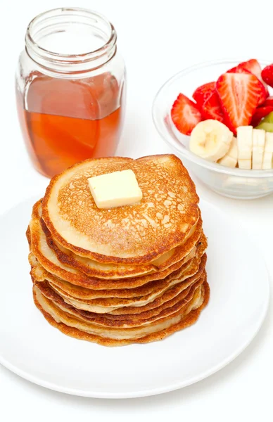 Golden buttermilk pancakes and jar of honey — Stock Photo, Image