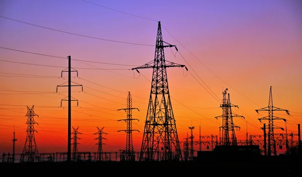 Elektrik direkleri karşı günbatımı — Stok fotoğraf