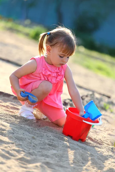 Menina brincando sozinha na areia — Fotografia de Stock