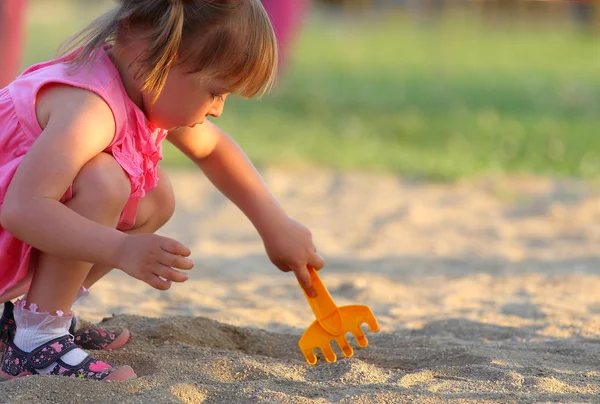 小さな女の子が砂場で遊んで — ストック写真