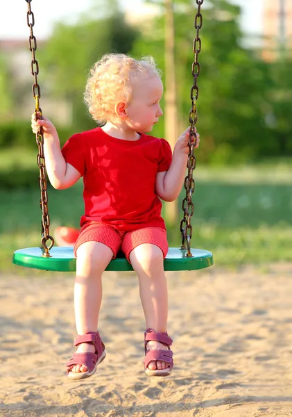 Маленька дівчинка на гойдалці в парку — стокове фото