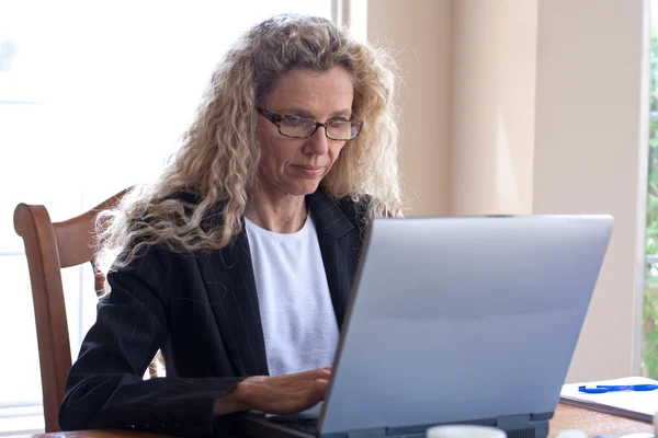 Женщина на столе с ноутбуком — стоковое фото