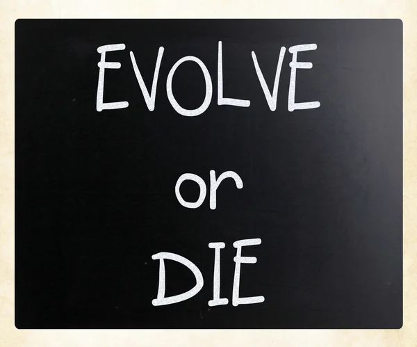 "Evolve or Die "handwritten with white chalk on a blackboard — стоковое фото