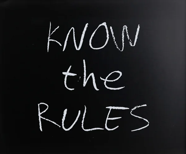 "Znáte pravidla"v rukou s bílou křídou na tabuli — Stock fotografie