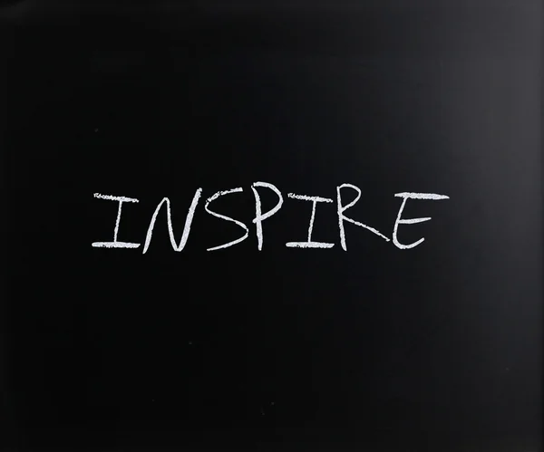 "Inspireer "handgeschreven met wit krijt op een Blackboard — Stockfoto