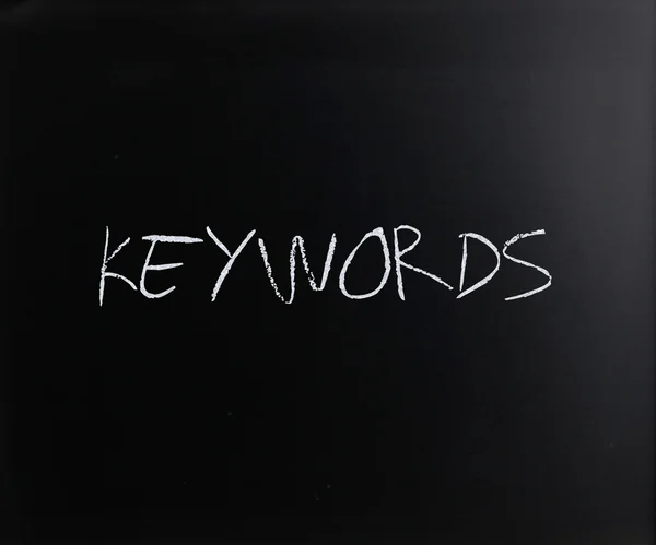 Слово "Ключевые слова" написано от руки с белым мелом на доске — стоковое фото