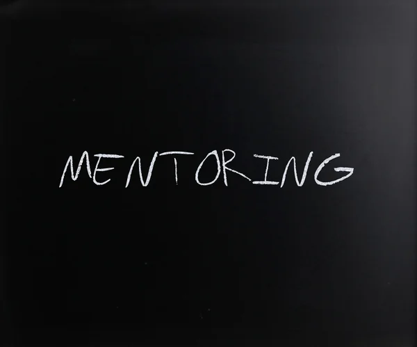 "Mentoring "handgeschreven met wit krijt op een Blackboard — Stockfoto