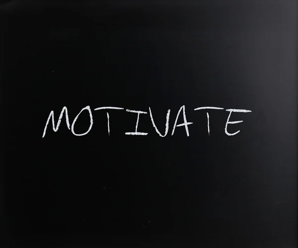 "motivovat "vlastnoručně psaný bílou křídou na tabuli — Stock fotografie