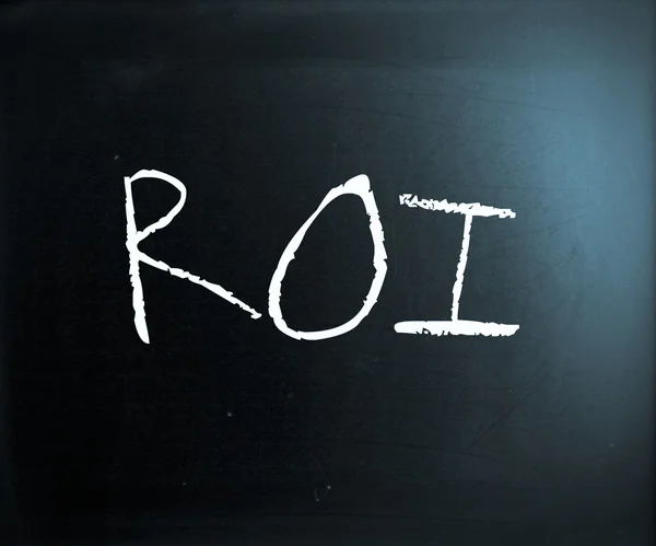 The word "ROI" handwritten with white chalk on a blackboard — Stock Photo, Image
