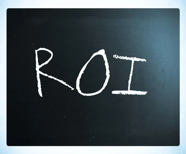 A palavra "ROI" manuscrita com giz branco em um quadro-negro — Fotografia de Stock