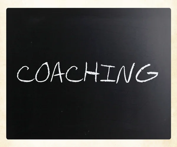 "Coaching "handwritten with white chalk on a blackboard — стоковое фото