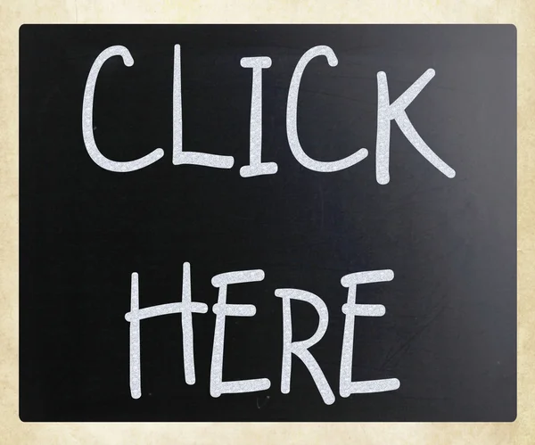 "Click here" handwritten with white chalk on a blackboard — Stock Photo, Image