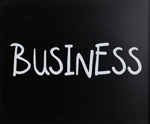 Het woord "business" met de hand geschreven met wit krijt op een schoolbord — Stockfoto