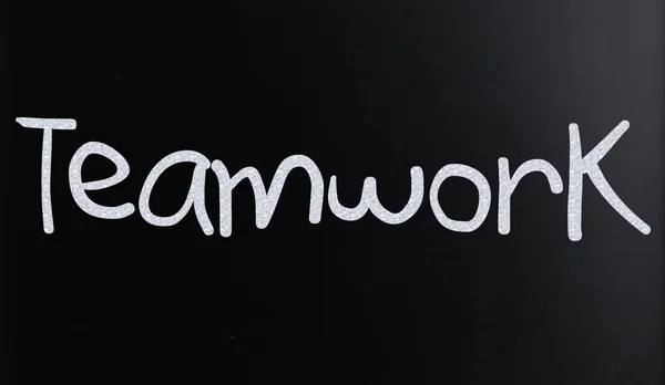 La palabra "Trabajo en equipo" escrita a mano con tiza blanca en una pizarra —  Fotos de Stock