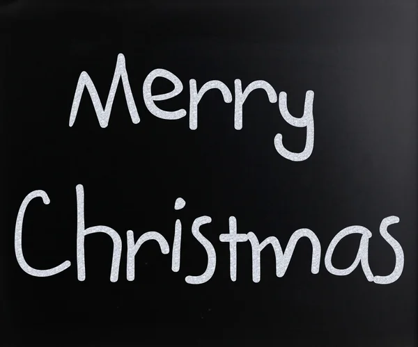 "Merry Christmas" handwritten with white chalk on a blackboard — Stock Photo, Image
