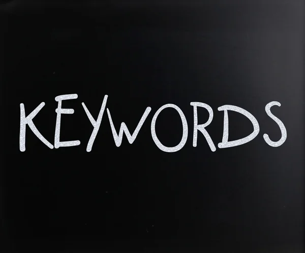Kelime "anahtar kelimeler üzerine bir yazı tahtası Beyaz tebeşir ile el yazısı" — Stok fotoğraf