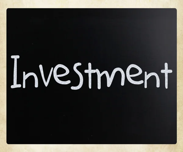 Le mot "investissement" écrit à la main avec de la craie blanche sur un blackboa — Photo