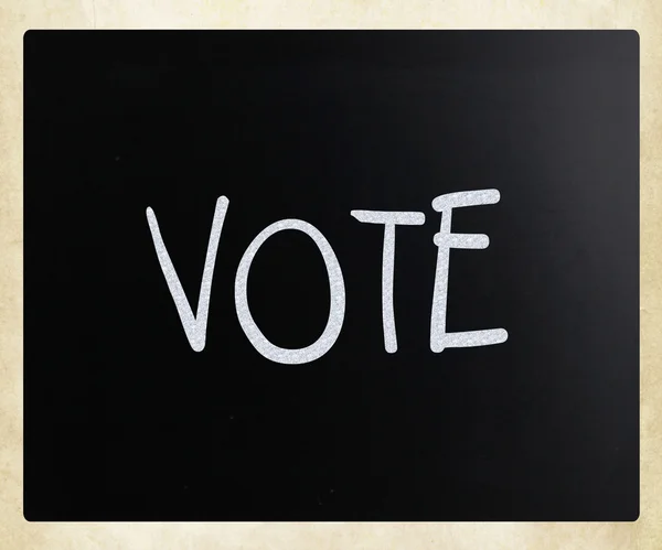 A palavra 'Vote' escrito à mão com giz branco em um quadro-negro — Fotografia de Stock