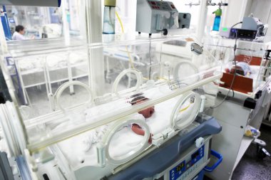 Newborn baby inside incubator clipart