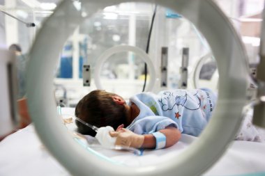Newborn baby inside incubator clipart