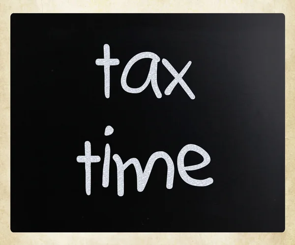 "Tax time" handwritten with white chalk on a blackboard — Stock fotografie