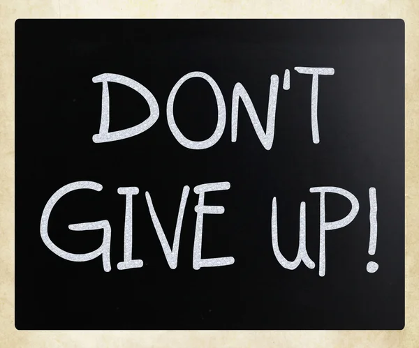 "Don't give up" handwritten with white chalk on a blackboard — Stock Photo, Image