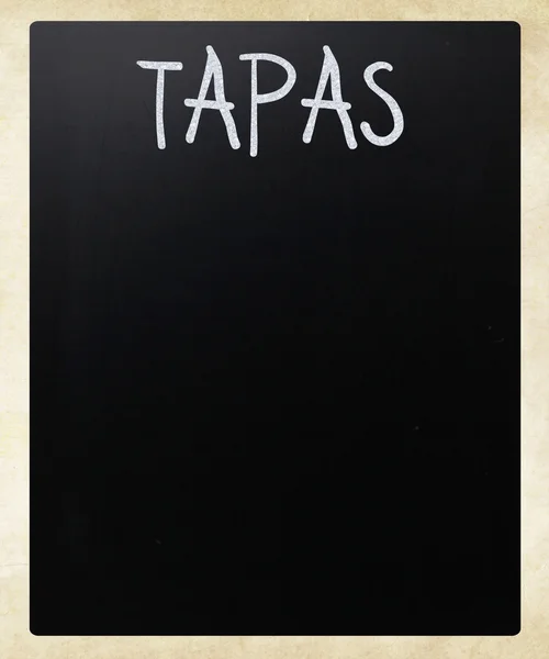"Tapas" handwritten with white chalk on a blackboard — Stockfoto