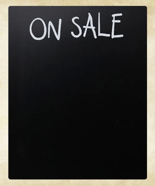 "Satışta" bir tahta üzerinde beyaz tebeşir ile el yazısı — Stok fotoğraf