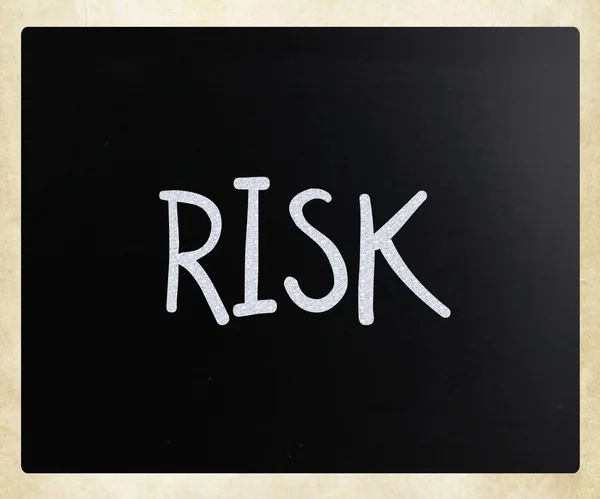 Слово "риск" написано от руки белым мелом на доске — стоковое фото