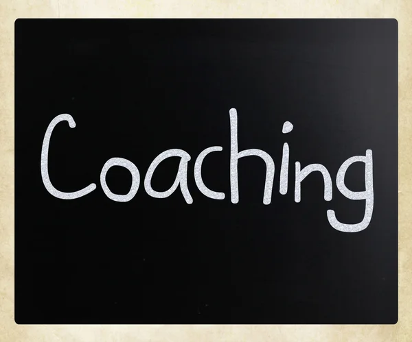 "Coaching "handwritten with white chalk on a blackboard — стоковое фото